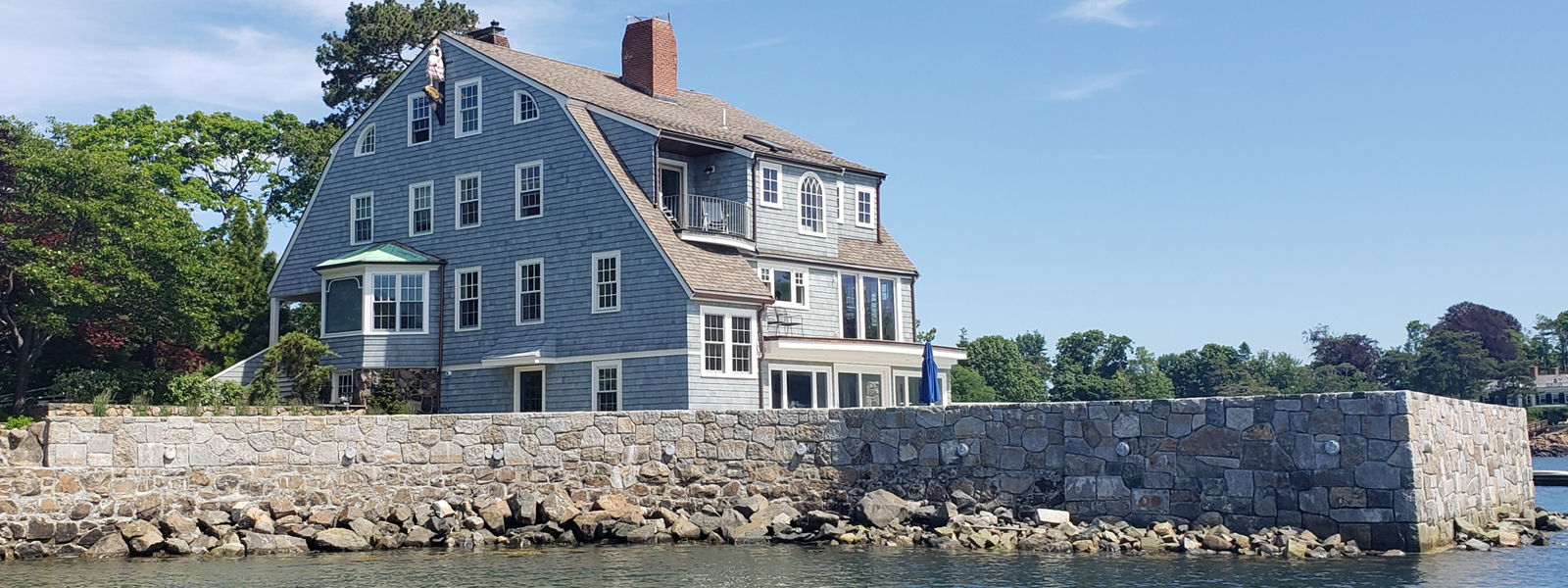 Waterfront home with decorative brick retaining wall that includes drainage solutions by Vice Brothers