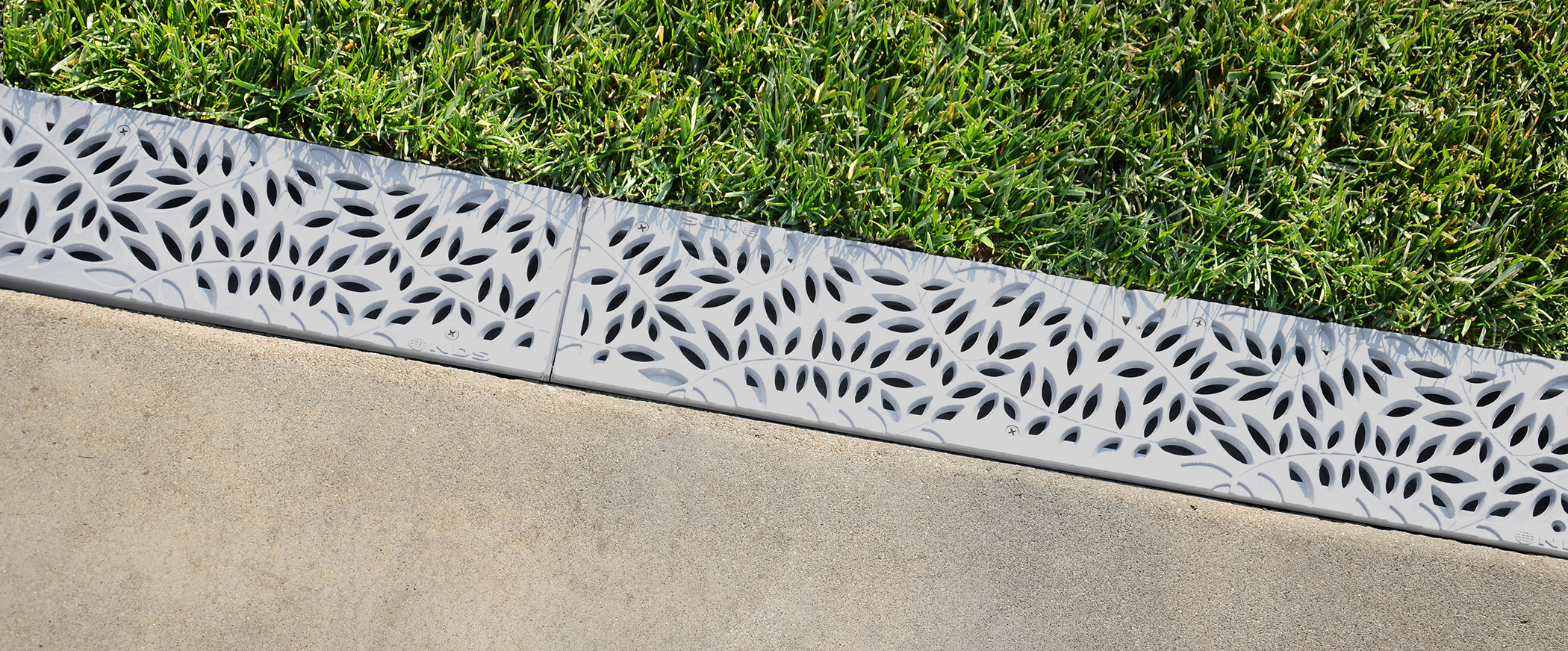 Channel drain installed along a residential driveway to prevent water buildup
